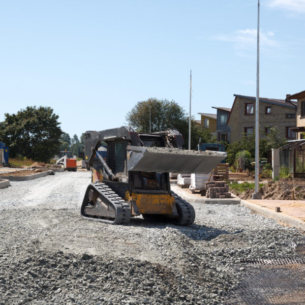 construction of a new street. mini excavator bobcat mowing breakstone