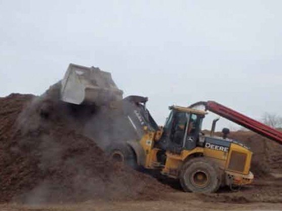Loader working a double shredded hardwood mulch pile