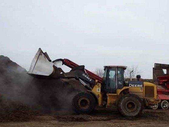Front-end loader scooping bulk hardwood mulch