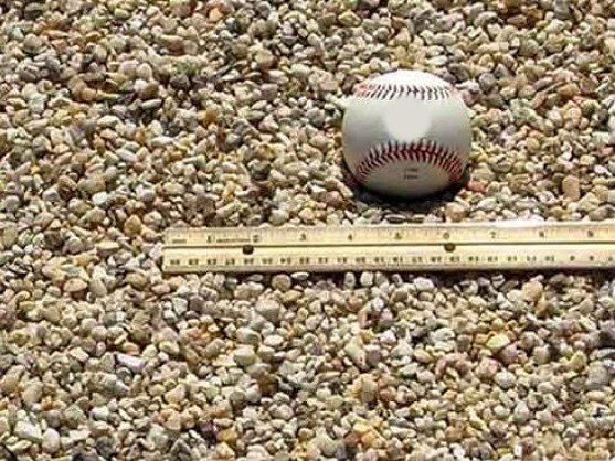 Pea gravel with a baseball and ruler for size, delivered in MD and VA