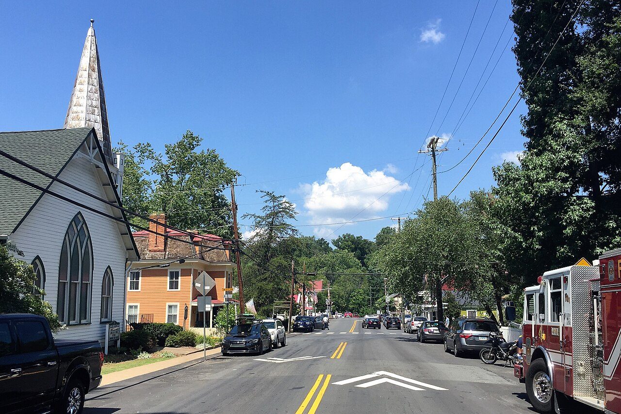 Tree-lined Main Street in historic Clifton with a white church steeple
