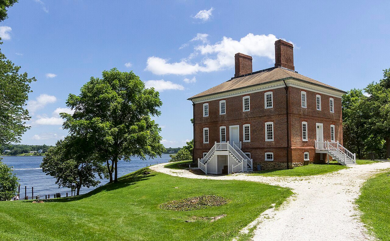 Historic brick London Town Publik House on a green lawn beside the South River in Edgewater