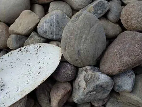 1-3 inch decorative river rock with a shovel
