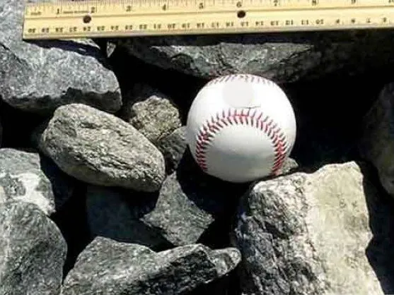 Gabion stone next to a baseball for size