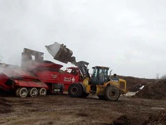 Loader filling a delivery truck with double shredded hardwood mulch