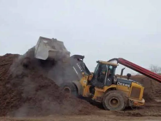 Loader working a double shredded hardwood mulch pile