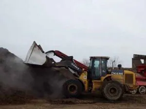 Front-end loader scooping bulk hardwood mulch