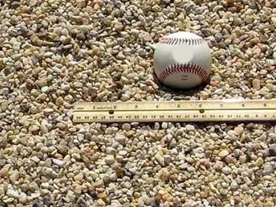 Pea gravel with a baseball and ruler for size, delivered in MD and VA