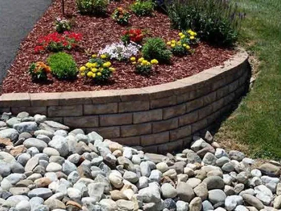 3-5 inch river rock landscaping below a retaining wall
