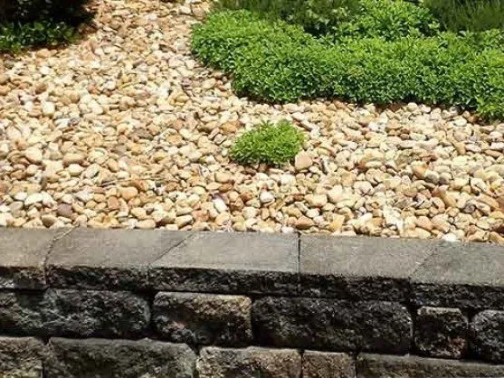 River washed gravel landscaping along a retaining wall