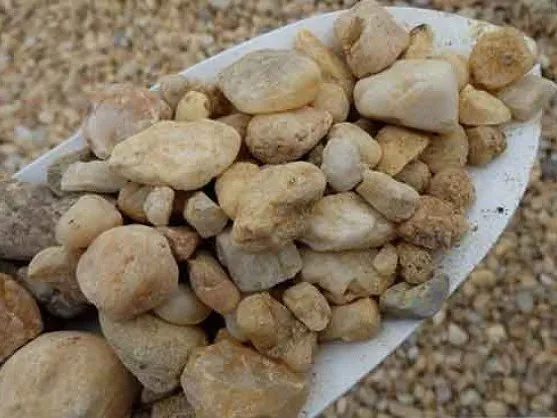 River washed gravel on a shovel