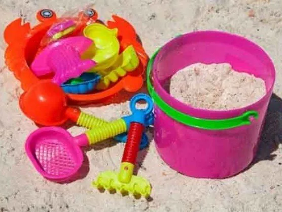 Beach toys in white sandbox play sand