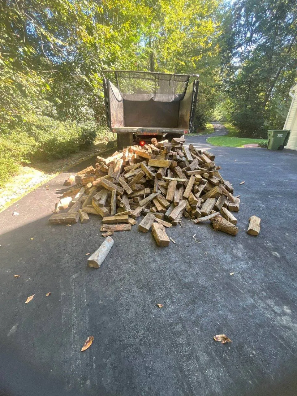 Seasoned firewood dumped on a driveway from our delivery truck